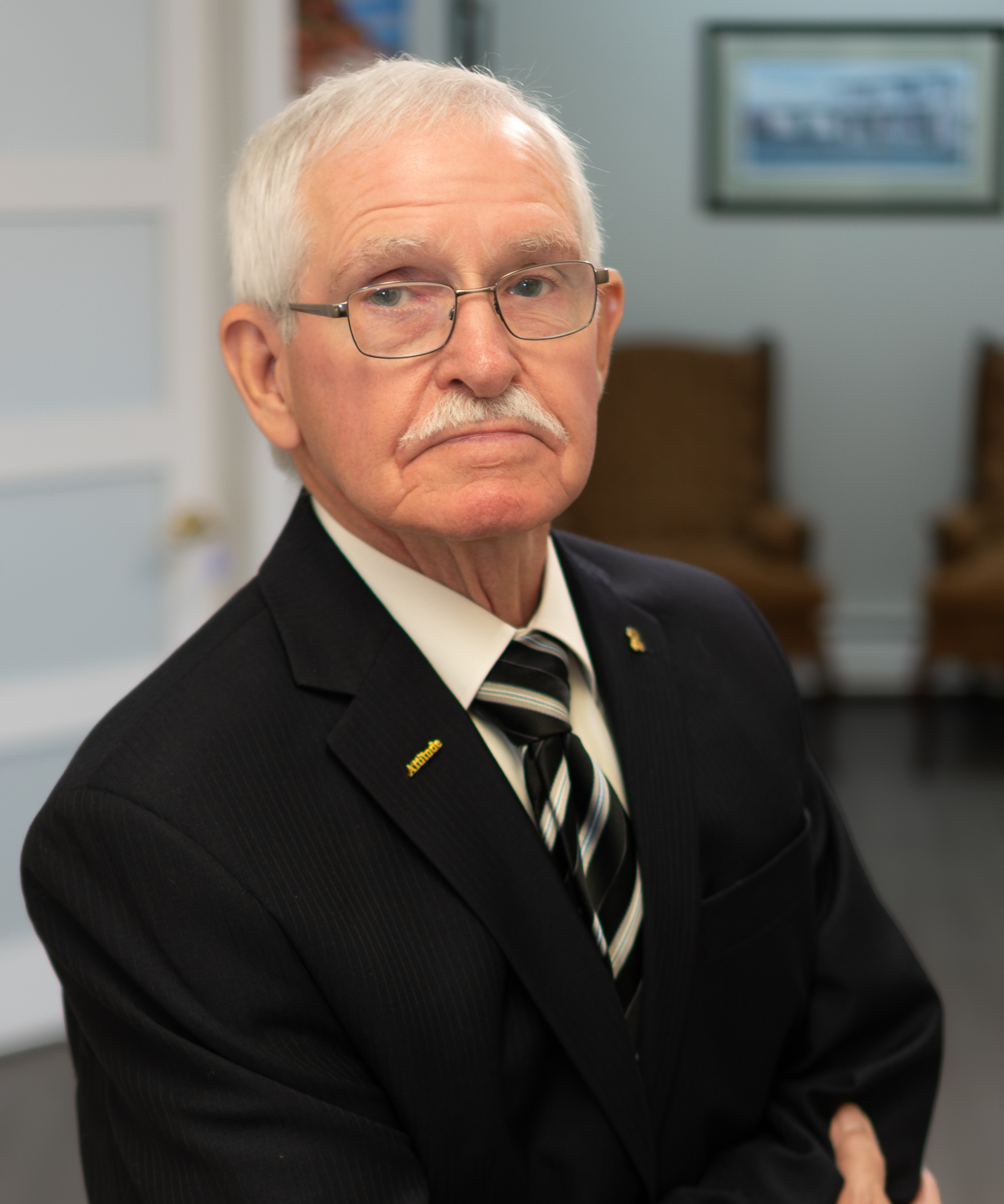 Ed Dawson, Senior Financial Consultant at Dawson & Associates IG Private Wealth Management, wearing a dark suit, striped tie, and glasses in a professional office portrait.