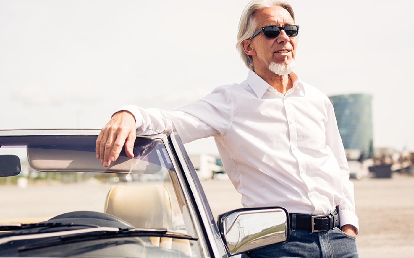 man posing by car