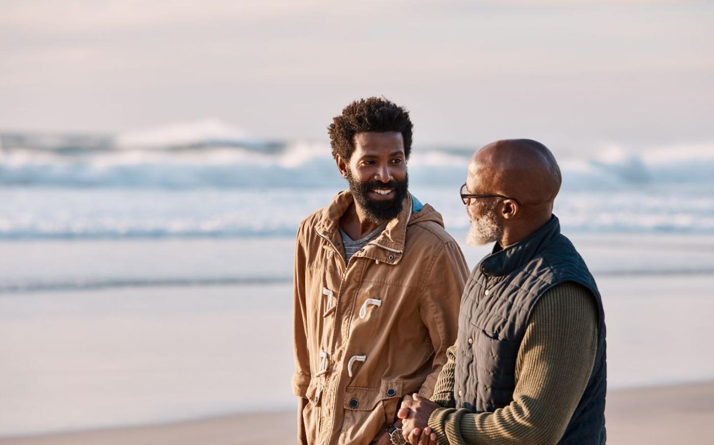 Two men talking on the beach
