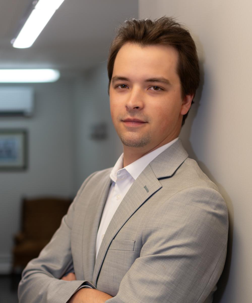 Devon Parsons, Associate Consultant at Dawson & Associates IG Private Wealth Management, wearing a light grey blazer and white shirt in a professional office portrait.