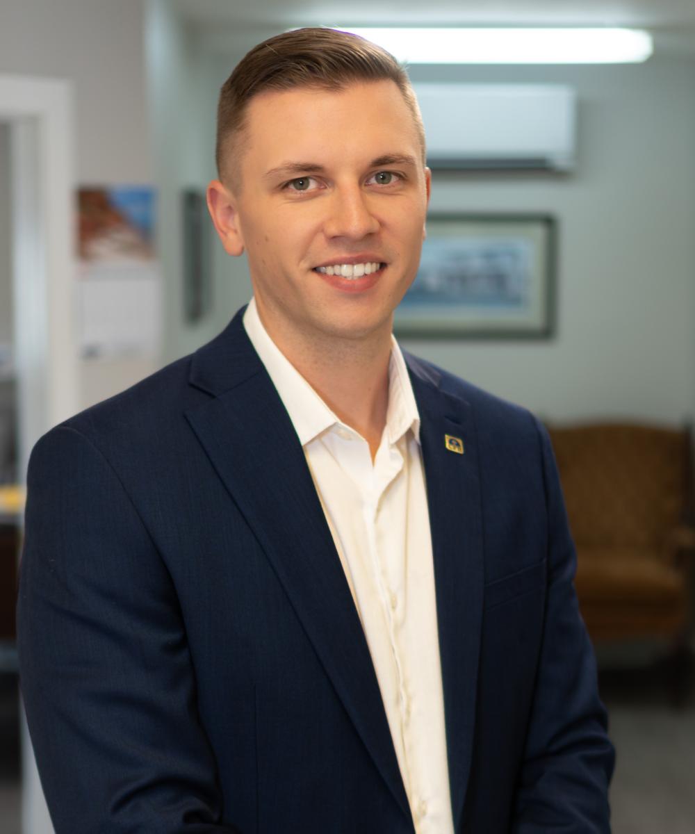 Brandon Barrett, Senior Wealth Advisor at Dawson & Associates IG Private Wealth Management, wearing a navy suit jacket and white shirt in a professional office portrait.