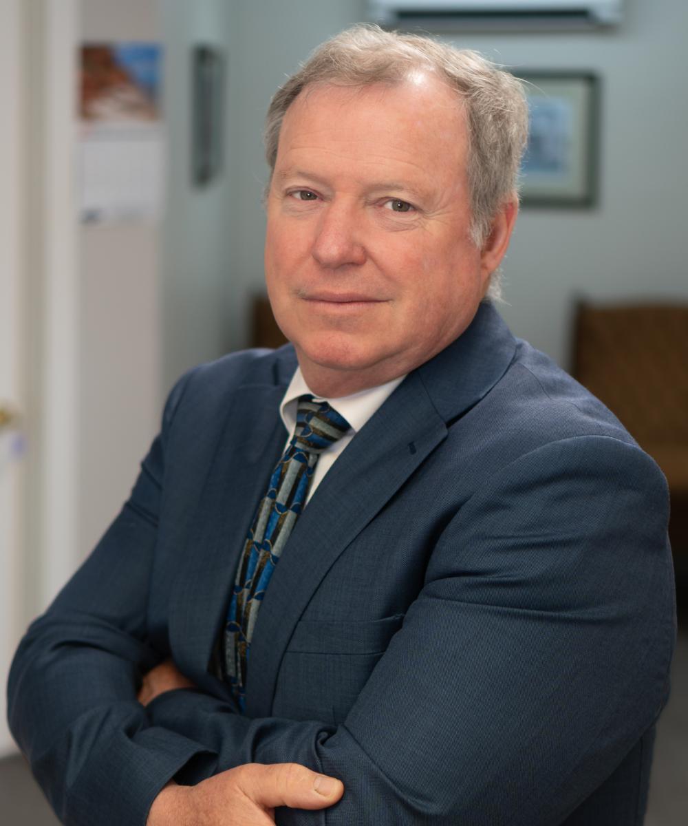 Chris Dawson, Senior Wealth Advisor at Dawson & Associates IG Private Wealth Management, wearing a blue suit and patterned tie in a professional office portrait.