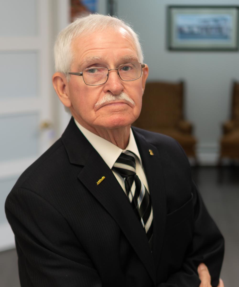 Ed Dawson, Senior Financial Consultant at Dawson & Associates IG Private Wealth Management, wearing a dark suit, striped tie, and glasses in a professional office portrait.