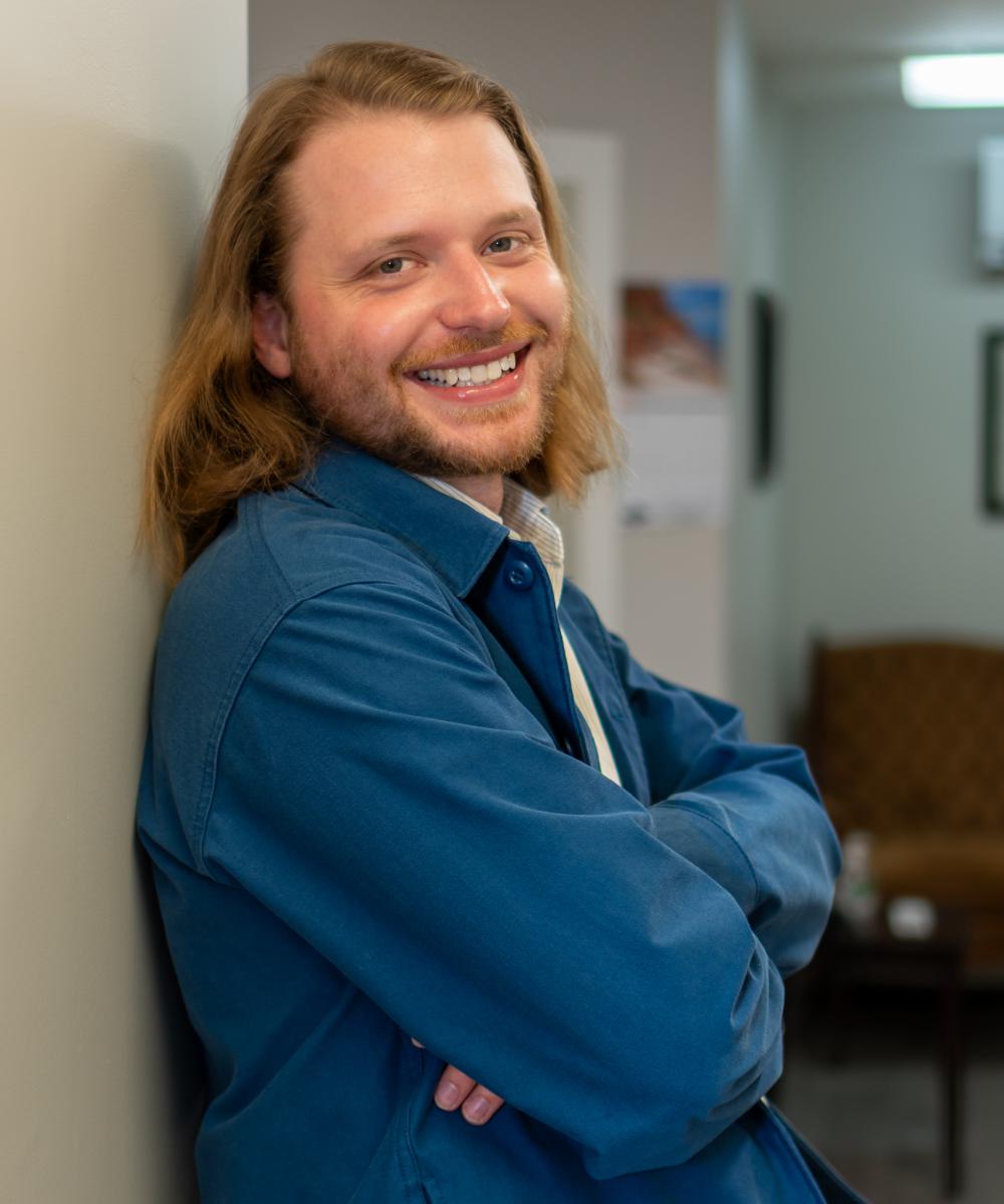 Patrick Dawson, Social Media Coordinator at Dawson & Associates IG Private Wealth Management, wearing a blue jacket and light shirt in a professional office portrait.